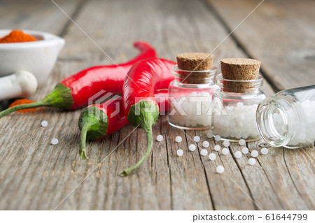 Chili peppers and bottles of homeopathic globules 61644799