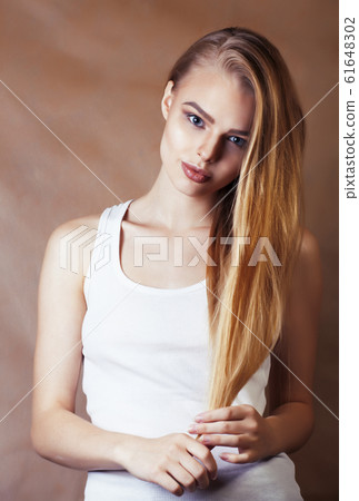 young pretty blond woman with fresh natural makeup posing cheerful on browm background, lifestyle people concept 61648302