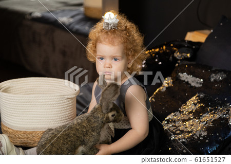 Beautiful little girl child on a New Year's bed Beautiful little girl child on a New Year's bed 61651527