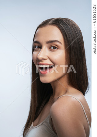 Charming girl posing for camera against light background Charming girl posing for camera against light background 61651528