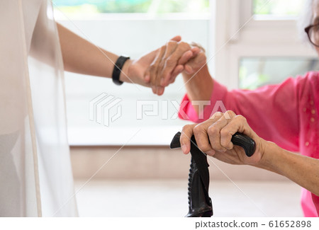 Close up of senior woman and young woman holding hand ,people,age,family,care and support concept 61652898