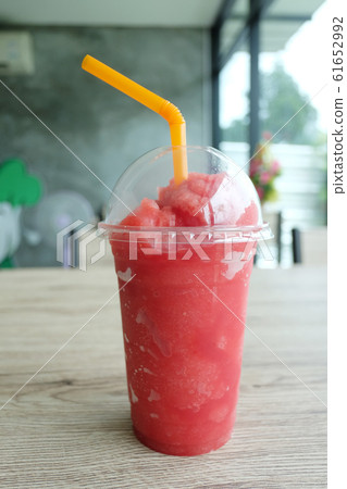 Red melon juice in plastic glass on the table. Red melon juice in plastic glass on the table. 61652992