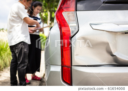 Insurance agent writing on clipboard while examining the car after accident claim was assessed and processed,traffic accident and insurance concept Insurance agent writing on clipboard while examining the car after accident claim was assessed and processed,traffic accident and insurance concept 61654008