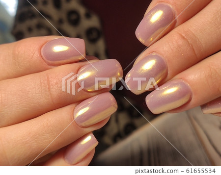 Partial view of manicurist gently holding hand 61655534