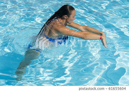 Woman diving in the swimming pool. Young beautiful 61655604