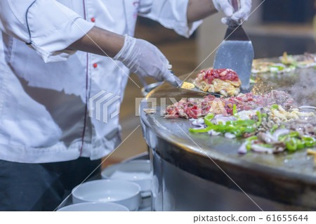 The cook in the restaurant fries food on a large 61655644
