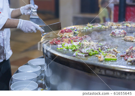 Cooking street food on a large firebox. Frying 61655645