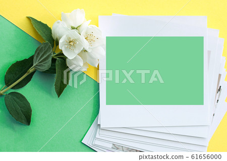 printed photos, frame cards, on a turquoise background with a white jasmine flower. Mock up. copy space. place for text printed photos, frame cards, on a turquoise background with a white jasmine flower. Mock up. copy space. place for text 61656000