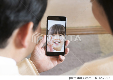 Grandparents and their couple video chatting with their grandchildren on a smartphone 61657022