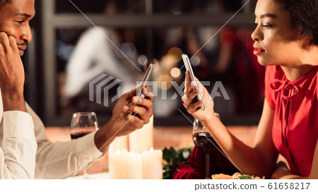 Bored Couple Using Smartphones On Romantic Dinner In Restaurant, Panorama Bored Couple Using Smartphones On Romantic Dinner In Restaurant, Panorama 61658217