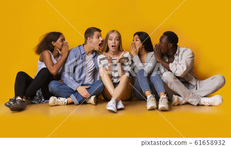 Shocked girl listening to her classmates whispers 61658932