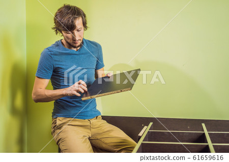 Frustrated Man Putting Together Self Assembly Furniture Frustrated Man Putting Together Self Assembly Furniture 61659616
