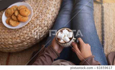 Young woman enjoying hot chocolate with marshmallows Young woman enjoying hot chocolate with marshmallows 61659617