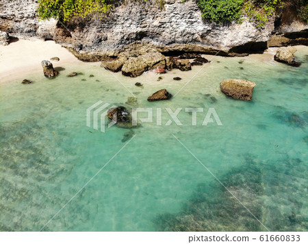 Aerial view of an amazing little beach with rock cliff in Bali. 61660833