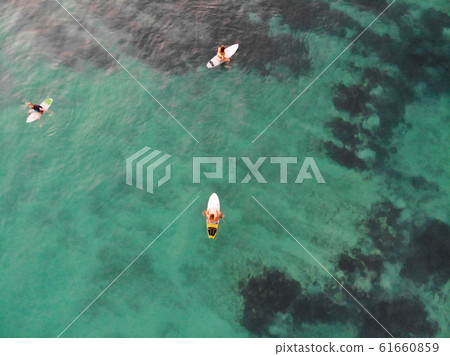 Aerial view of surfers waiting the waves in blue clear water. 61660859