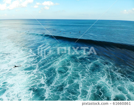 Aerial view of surfers on their board catching the waves 61660861
