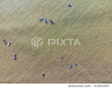 Aerial view of surfers waiting the waves in the dark, brown water in Bali, Indonesia 61661007