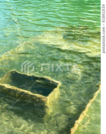Abandoned boat in flooded quarry with blue crystal water. Abandoned boat in flooded quarry with blue crystal water. 61661039