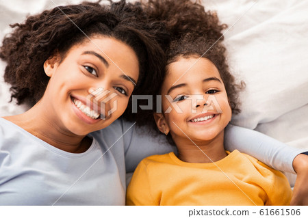 Afro Mother And Daughter Lying In Bed In Bedroom, Top-View 61661506
