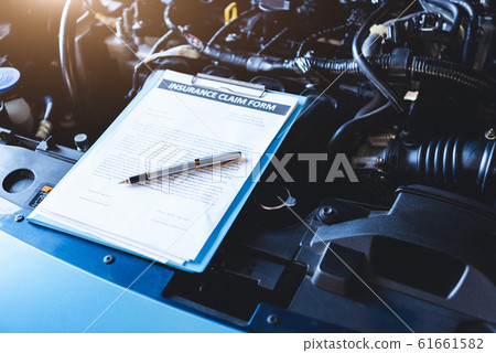Clipboard on car with car insurance claim form for 61661582