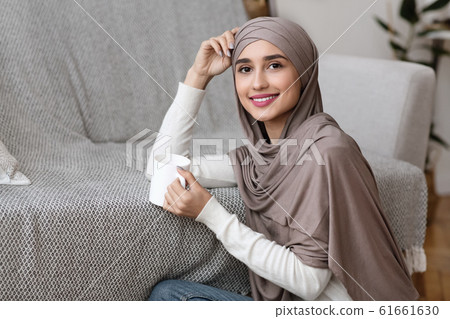 Relaxed Muslim Girl Sitting On Floor With Cup Of Tea 61661630