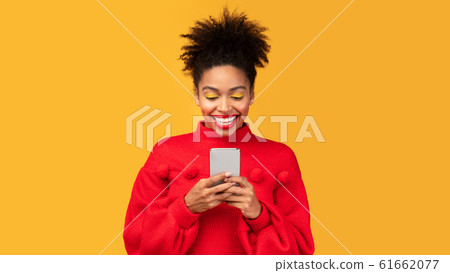 Smiling afro girl using cell phone at studio 61662077
