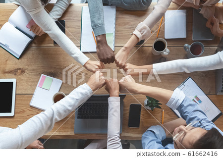 People putting fists together for cooperation, cropped People putting fists together for cooperation, cropped 61662416