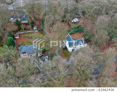 Aerial view of big villas with garden surrounded by forest during winte season 61662436