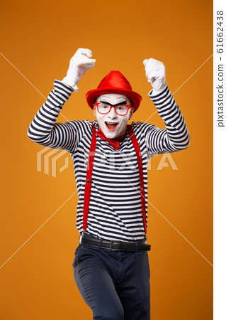 Happy mime man in vest and red hat Isolated on orange background 61662438
