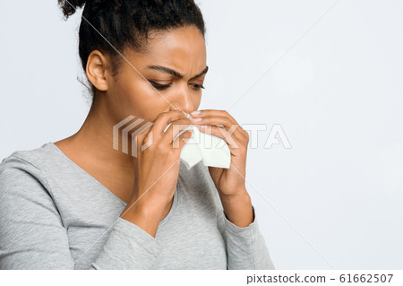 Woman wiping her nose with napkin, having flue Woman wiping her nose with napkin, having flue 61662507