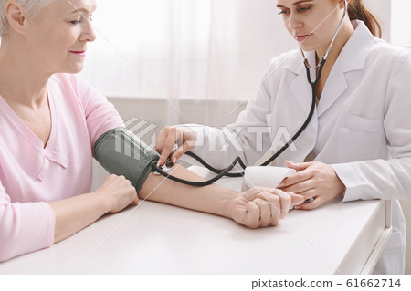 Doctor measuring arterial blood pressure for senior patient 61662714