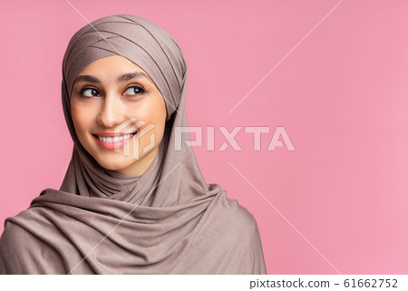 Curious muslim woman in hijab looking at copy space with interest 61662752