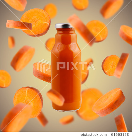 Detox carrot drink with flying components on brown Detox carrot drink with flying components on brown 61663158