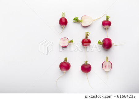 Composition of cut and whole radishes on white background 61664232