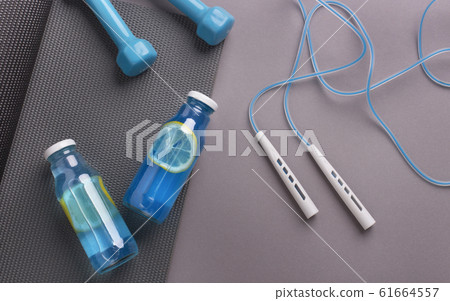 Detox isotonic water with lemon slices and gym accessories 61664557
