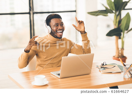 Young african businessman listening to music with headset 61664627