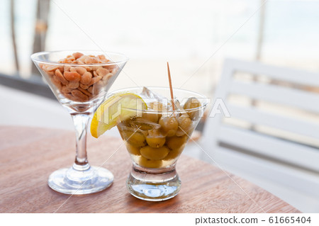 Green olives with lemon and ice and peanuts 61665404
