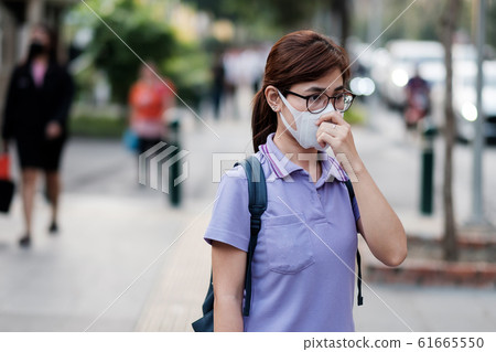 young Asian woman wearing N95 respiratory mask young Asian woman wearing N95 respiratory mask 61665550