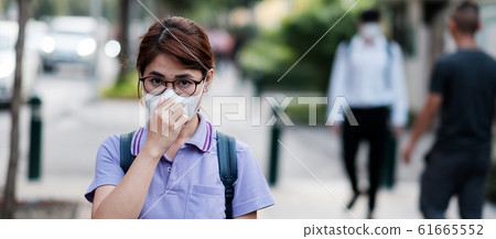 young Asian woman wearing N95 respiratory mask young Asian woman wearing N95 respiratory mask 61665552