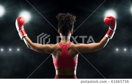 Back view of black woman boxer champion celebrating win Back view of black woman boxer champion celebrating win 61665736