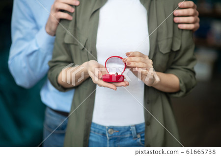 Man and a woman holding an engagement ring box 61665738