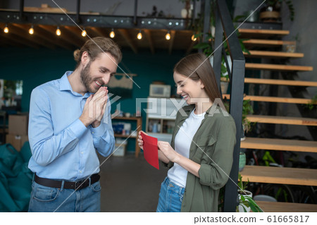 Smiling woman and man opening an envelope Smiling woman and man opening an envelope 61665817