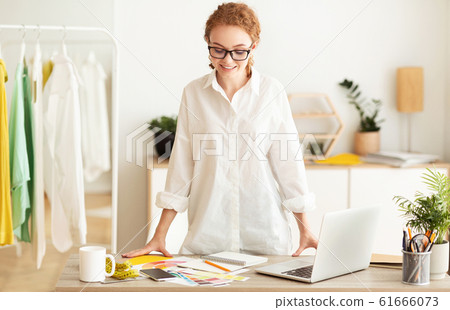 Happy tailor working in own dressmaking studio Happy tailor working in own dressmaking studio 61666073