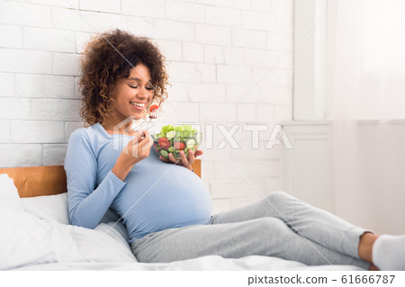 Pregnancy meal plan. African-american woman eating fresh vegetable salad Pregnancy meal plan. African-american woman eating fresh vegetable salad 61666787