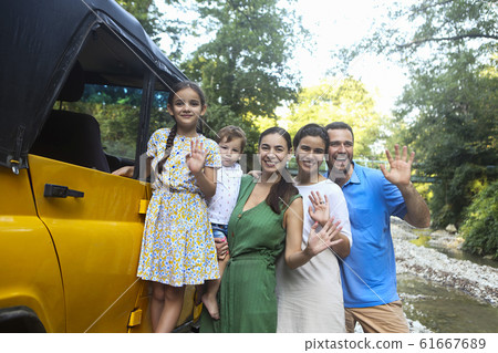 Happy smiling family with kids by the car with 61667689