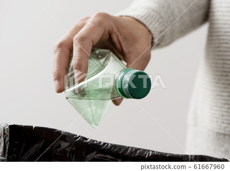 man throwing a plastic bottle to the trash bin man throwing a plastic bottle to the trash bin 61667960