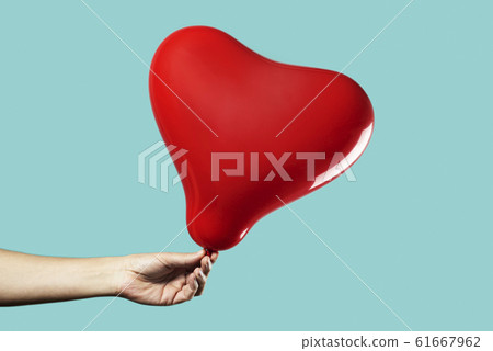 man with a red heart-shaped balloon man with a red heart-shaped balloon 61667962