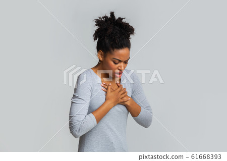 Sad young woman suffering from acute pain in chest 61668393