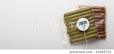 Pack of meatless sausages lying on white table, panorama 61668728