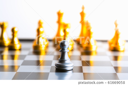One gold pawn chess piece is standing alone on chessboard One gold pawn chess piece is standing alone on chessboard 61669058